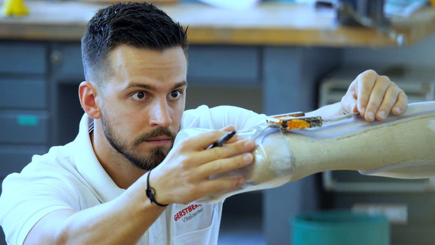 Mann in der Werkstatt, der eine Prothese fertigt